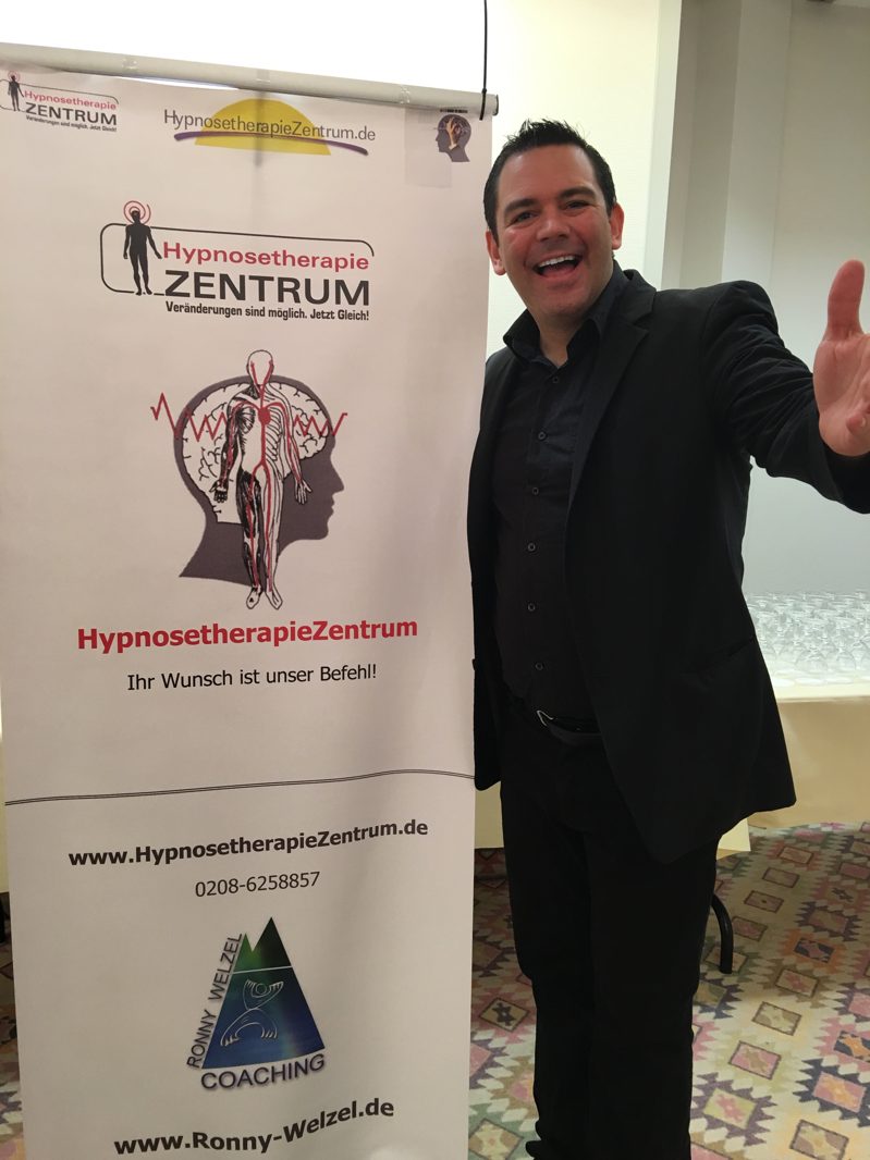 Ronny Welzel neben dem Roll-up des HypnosetherapieZentrums